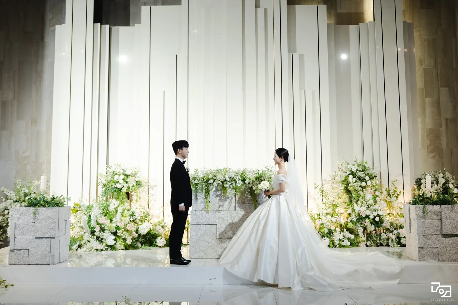 미엘르홀 밝은 무대 앞에서 마주 선 신랑신부님