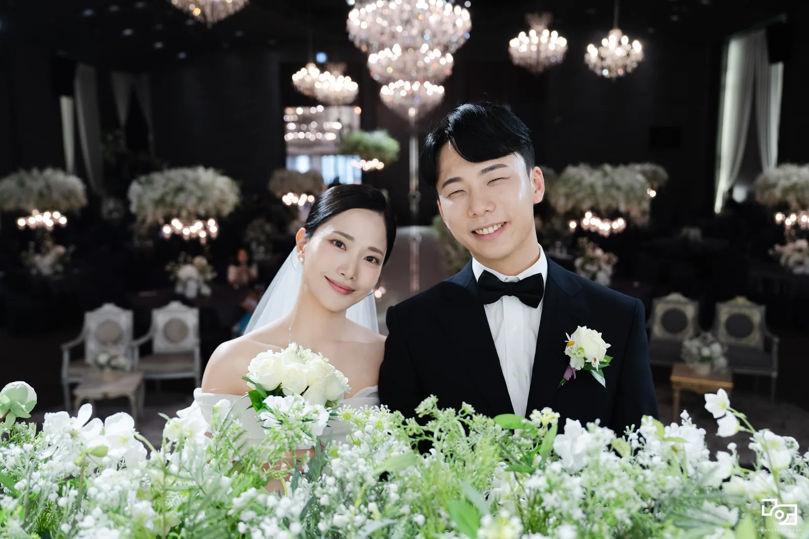 본식 후 꽃장식 앞에서 함께 웃는 신랑신부님